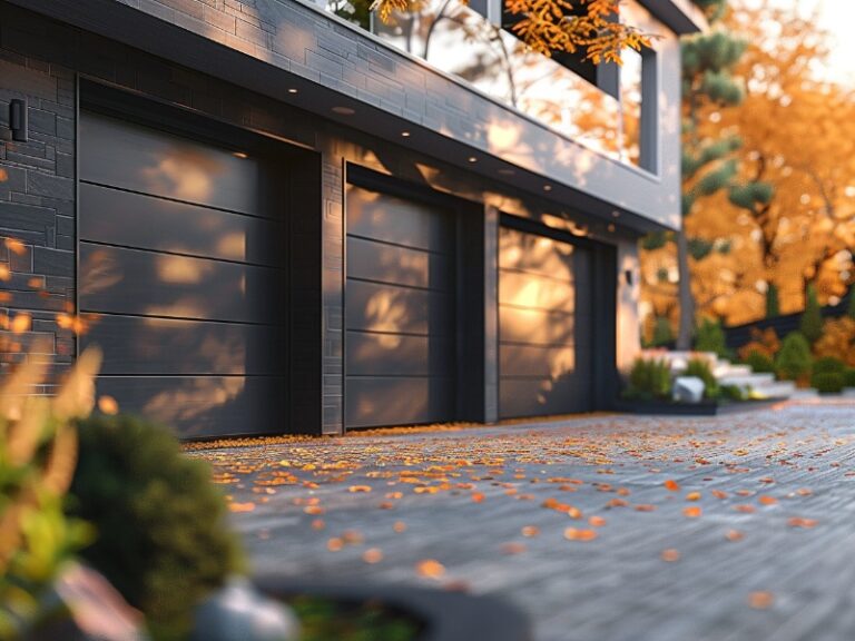 "Contemporary home exterior with sleek black garage doors surrounded by autumn foliage."